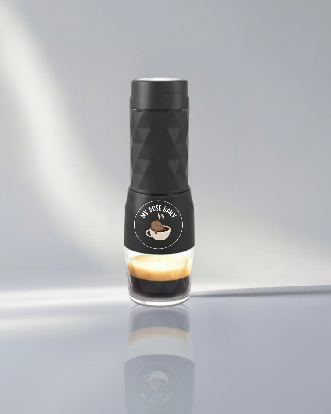 Black coffee maker with geometric design on a gray background