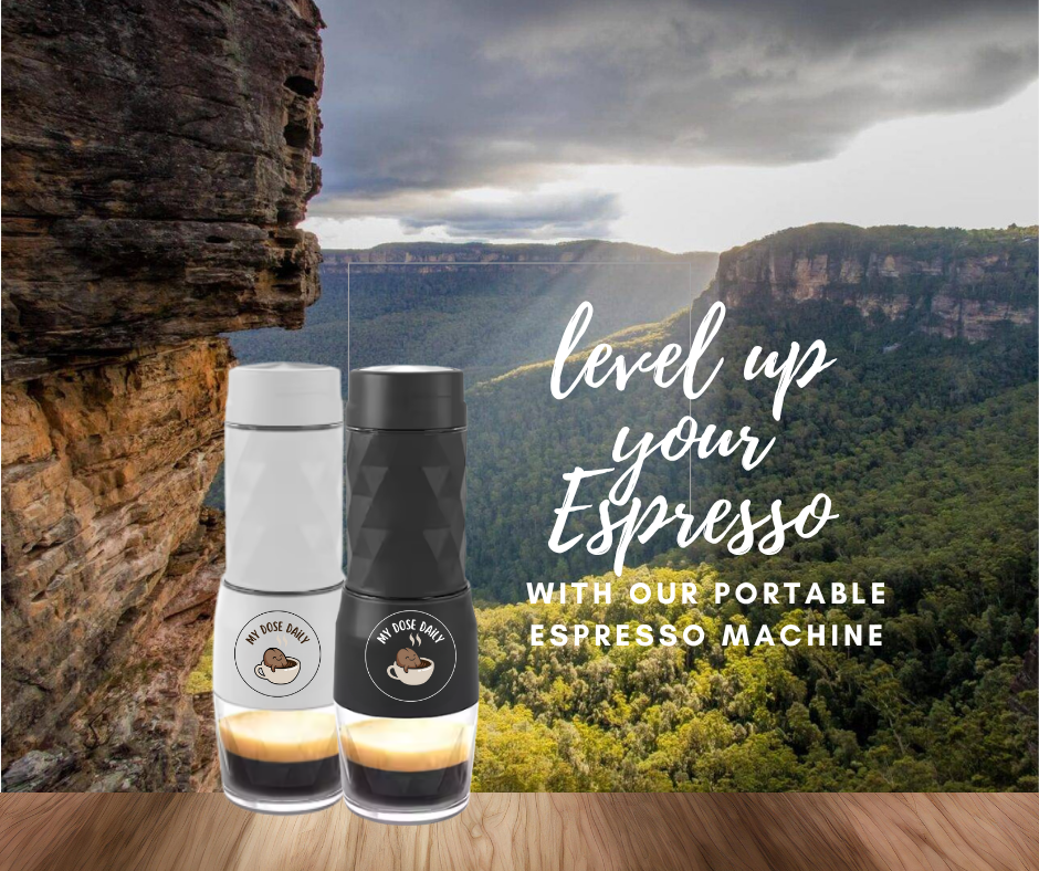 Two portable espresso machines on a wooden surface with a scenic mountain background.